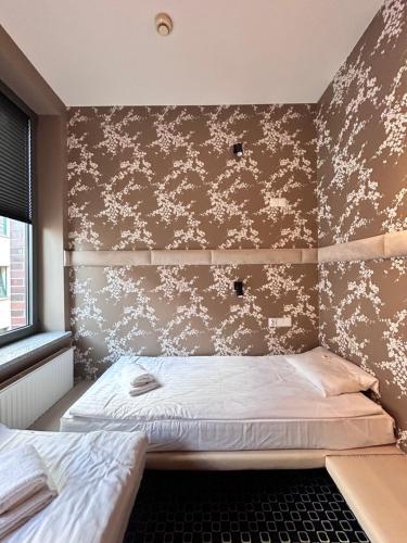 a bedroom with a bed and a wall with flowers at Amber Suite Szczecin hotel na Starym Mieście Adults Only in Szczecin