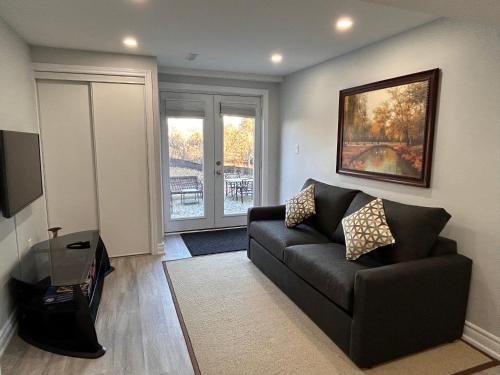 a living room with a couch and a television at Rita's Kunjo - 2BR, 3BD, 2WR, Full Ktchn, Living in Whitby