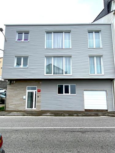 a gray house with two garage doors on a street at Apartamentos LAMAROSA -LAS PLAYAS in Burela de Cabo