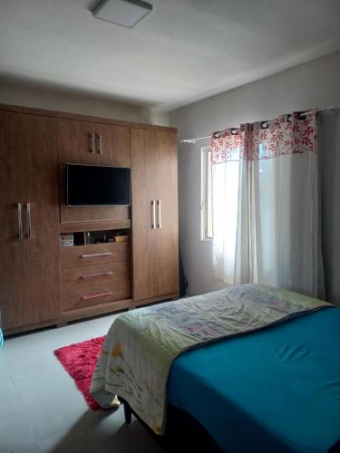 a bedroom with a bed and a tv and a window at Casa da Tranquilidade in Barra Velha