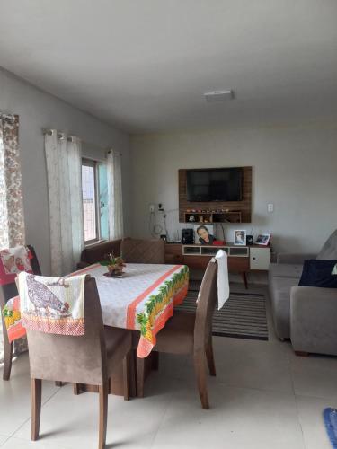 a living room with a table and chairs and a tv at Casa da Tranquilidade in Barra Velha