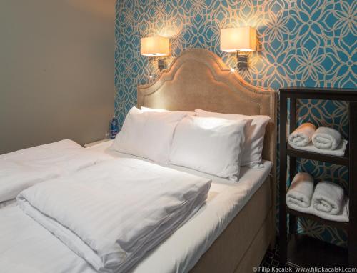 a bed with white sheets and pillows in a room at Amber Suite Szczecin hotel na Starym Mieście Adults Only in Szczecin