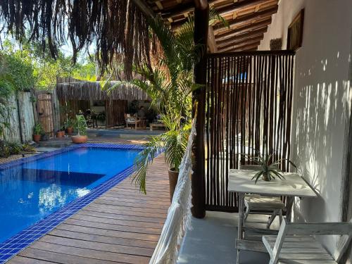 a swimming pool with a table and chairs next to a house at VILA TRANCOSEAR in Trancoso
