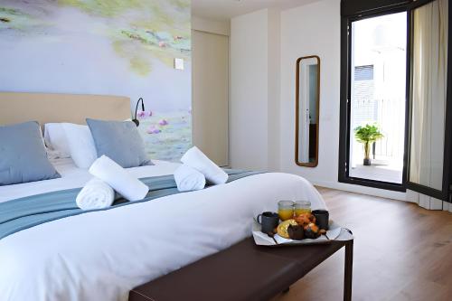 a bedroom with a large bed with a tray of food on it at Pepe Lux Ático centro de Málaga in Málaga