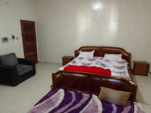 une chambre avec un lit, un canapé et une chaise dans l'établissement Apecsi, à Dakar