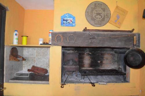 una cocina con una antigua chimenea en la pared en Casa Fabiana, en Villa Carlos Paz