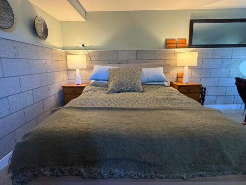 a bedroom with a bed with two lamps and a tv at Studio on Hobson in Auckland