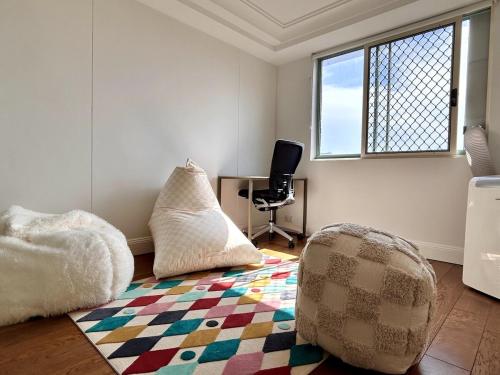 a room with a couch and a chair on a rug at 3BR Penthouse in CBD wParking in Sydney