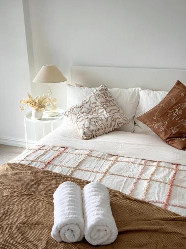 a bed with two towels on top of it at 3BR Penthouse in CBD wParking in Sydney