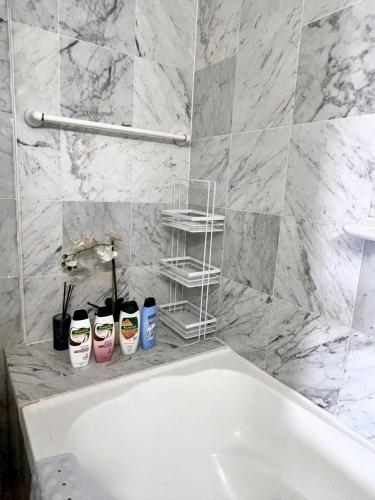 a bath tub in a bathroom with a marble wall at 3BR Penthouse in CBD wParking in Sydney