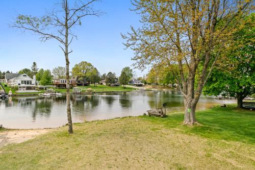 a park with a bench and trees next to a river at Loch Nez, a spacious 3-bedroom home in Silver Lake, MI in Mears