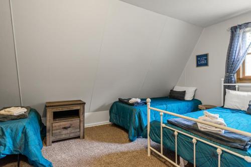 a room with two beds and a night stand in a room at Loch Nez, a spacious 3-bedroom home in Silver Lake, MI in Mears