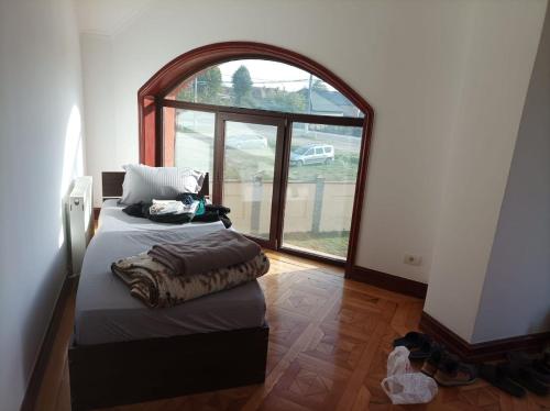 a bedroom with a bed and an arched window at Casa de vacanta in Târgu Jiu