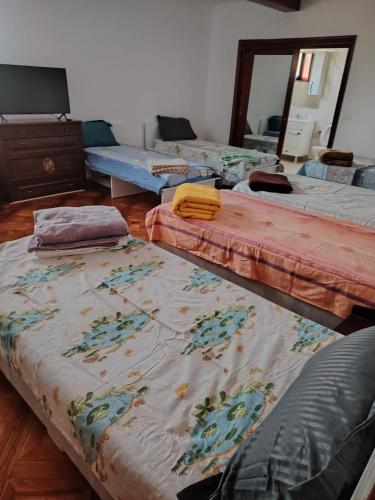 a room with three beds sitting on the floor at Casa de vacanta in Târgu Jiu