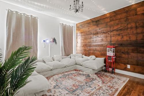 ダラスにあるBishop Arts District Boho Cinema Houseの白いソファと木製の壁が備わるリビングルーム