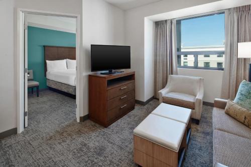 a hotel room with a bed and a flat screen tv at Staybridge Suites Irvine - John Wayne Airport by IHG in Irvine