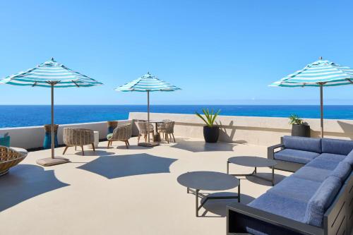 a patio with chairs and tables and umbrellas on the beach at OUTRIGGER Kona Resort and Spa in Kailua-Kona