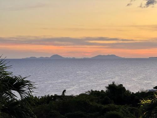 a view of the ocean at sunset at Charmant T3 en haut de villa, vue panoramique sur la mer in Le Gosier