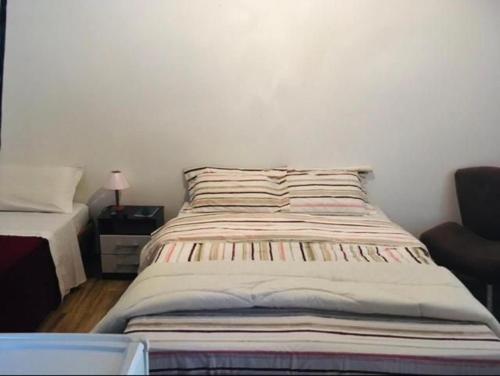 a bed in a room with a white wall at Pousada da Vovó in Conservatória