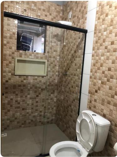 a bathroom with a toilet and a glass shower at Residencial da Ju in Bombinhas
