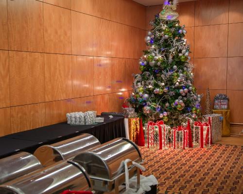 a christmas tree in a conference room with presents at iHOTEL & Conference Centre Red Deer in Red Deer