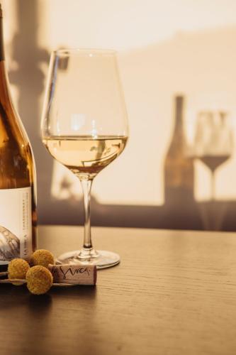 a glass of white wine sitting on a table at La Sirca Boutique Winery Cabins in Población