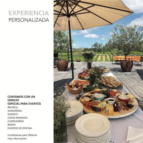a table with plates of food and an umbrella at La Sirca Boutique Winery Cabins in Población