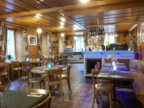 un ristorante con tavoli e sedie e un bar di Auberge de l'Ange ad Albeuve