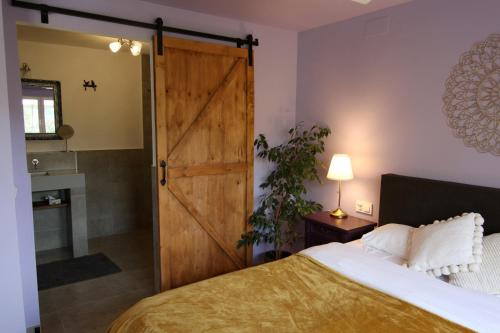 a bedroom with a bed and a sliding barn door at Villa Foia Vella - adults only in Benichembla