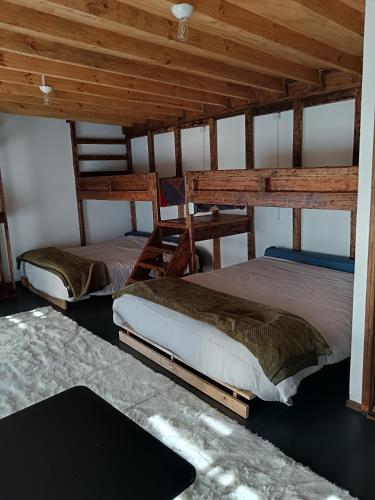 two bunk beds in a room with wooden ceilings at casa rural el saltillo in Pemuco