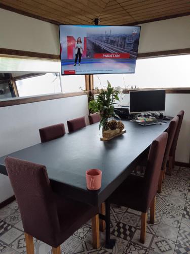 a dining room table with chairs and a tv at casa rural el saltillo in Pemuco