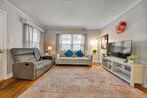 a living room with a couch and a television at Spacious 4BR Home with Cozy Vibes in Louisville in Louisville