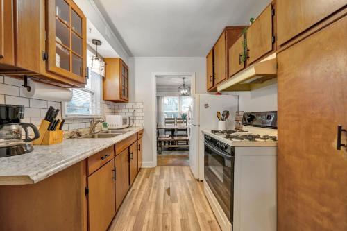 a kitchen with wooden cabinets and white appliances at Spacious 4BR Home with Cozy Vibes in Louisville in Louisville