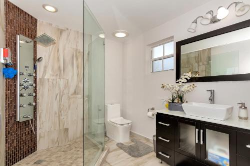 a bathroom with a glass shower and a sink at Tropical house Miami in Cutler Bay