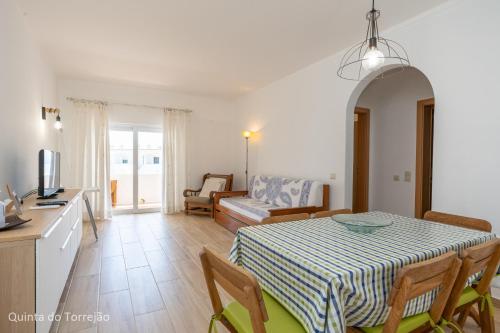 a dining room with a table and a living room at Renovated Algarve Apartments with Pool in Armação de Pêra