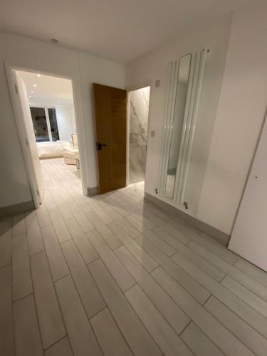 an empty room with white walls and wooden floors at The bay apartment in Stone Grove