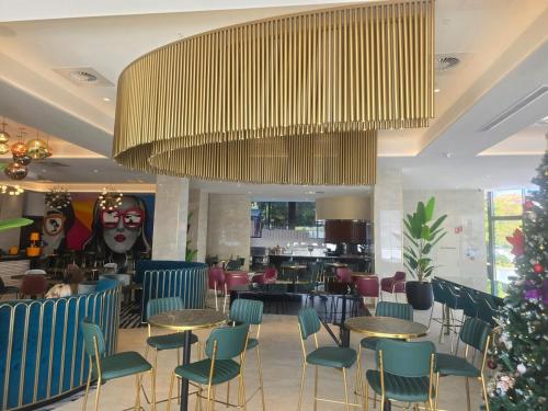 a restaurant with tables and chairs and a large chandelier at Southport Central Two bedroom Apartment Gold Coast in Gold Coast