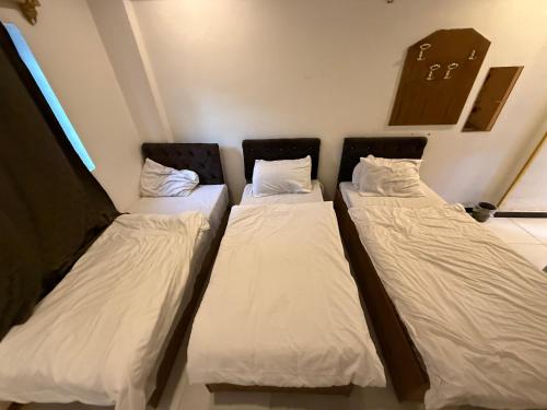 a group of three beds in a room at Sarko hotel فندق سركو in Baghdad