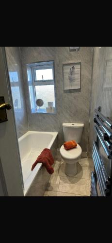 a bathroom with a tub and a toilet and a sink at Welcome to Islwyn in Ewloe