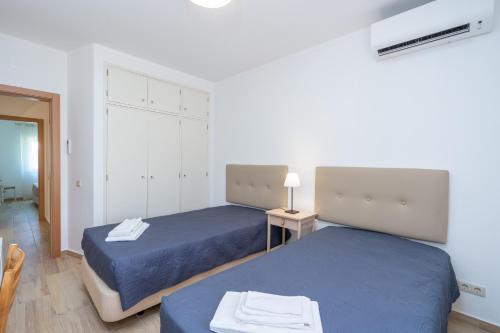 a bedroom with two beds and a table with a lamp at Renovated Algarve Apartments with Pool in Armação de Pêra
