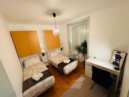 a small room with two beds and a desk at Hostel Arroios in Lisbon