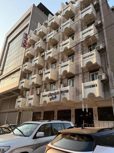 a building with cars parked in front of it at Sarko hotel فندق سركو in Baghdad