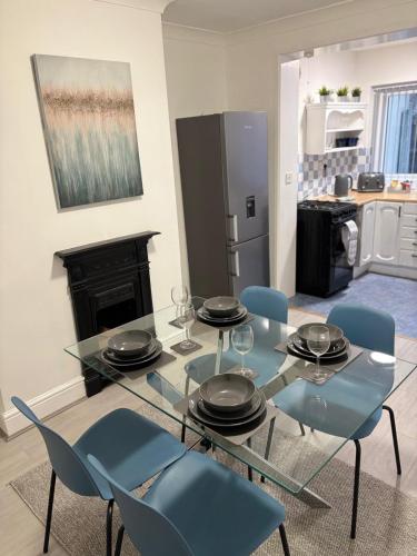 a dining room with a glass table and chairs at Cosy 2-bed NR New Cross Hospital in Wednesfield