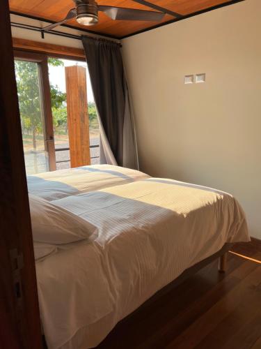 a bed in a bedroom with a ceiling fan at La Sirca Boutique Winery Cabins in Población