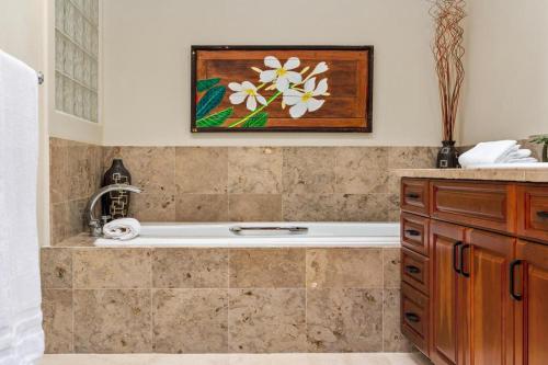 a bathroom with a tub and a painting on the wall at 518 Villages at Mauna Lani in Waikoloa