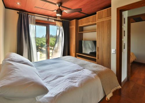 a bedroom with a large bed with a window at La Sirca Boutique Winery Cabins in Población