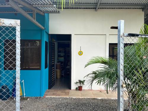 a blue and white house with a door and a plant at Uvita Oasis Retreat with Villa Cabins and Apartment in Uvita