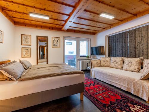 a bedroom with a large bed and a couch at Alpenlodge Steiger in Neukirchen am Großvenediger