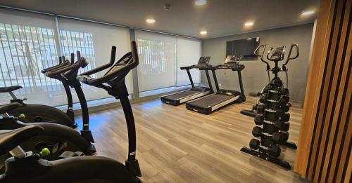 a gym with several tread machines in a room at Basq Propiedades - Barrio Republica 7 in Santiago