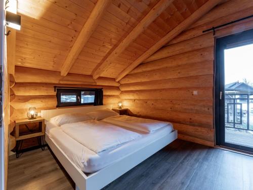 Cama en habitación de madera con ventana grande en Jenig 4B, en Jenig